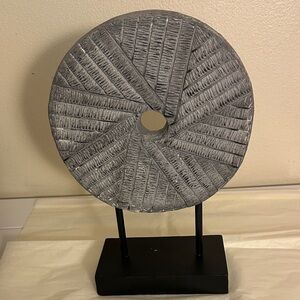 Decorative milestone mounted on a black stand